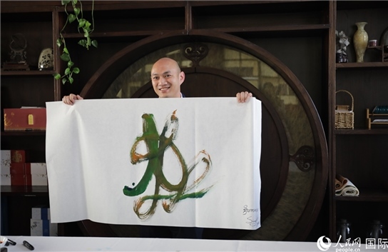 老撾駐華大使館三秘明君參加《五百筆·瀾湄合作》集體藝術創(chuàng)作。人民網王婧攝。