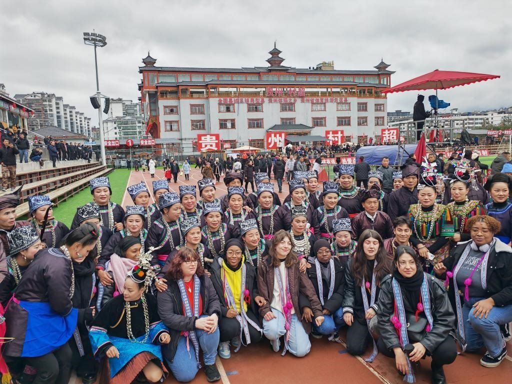 法國青年在“村超”賽場邊與參加表演的村民合影。新華社記者 羅羽 攝