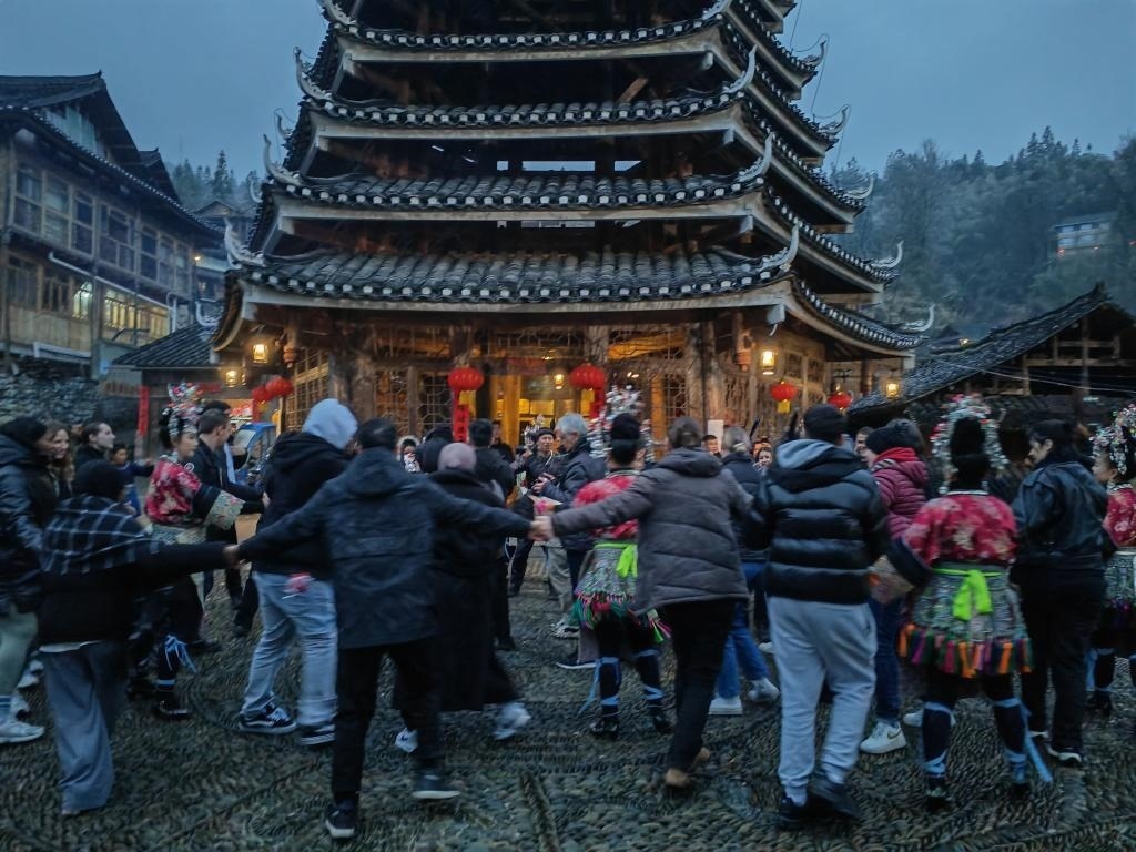 法國青年與當?shù)卮迕駹渴痔?。新華社記者 羅羽 攝