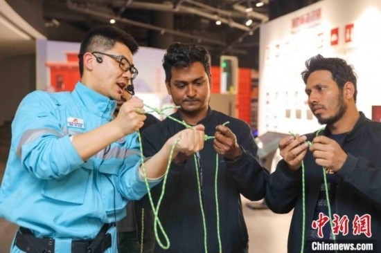 5月9日，工作人員指導留學生學習打繩結。張鷹 攝