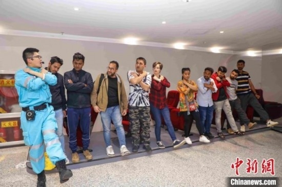 5月9日，工作人員指導留學生練習逃生技巧。張鷹 攝