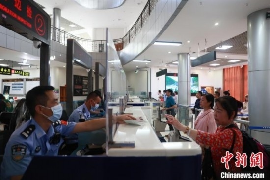 圖為旅客在磨憨口岸辦理通關(guān)手續(xù)。雷雨 攝