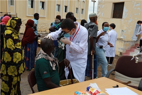 在義診現(xiàn)場，中國醫(yī)生與當(dāng)?shù)鼐用窈嫌傲裟?，吉布提鹽業(yè)投資公司供圖