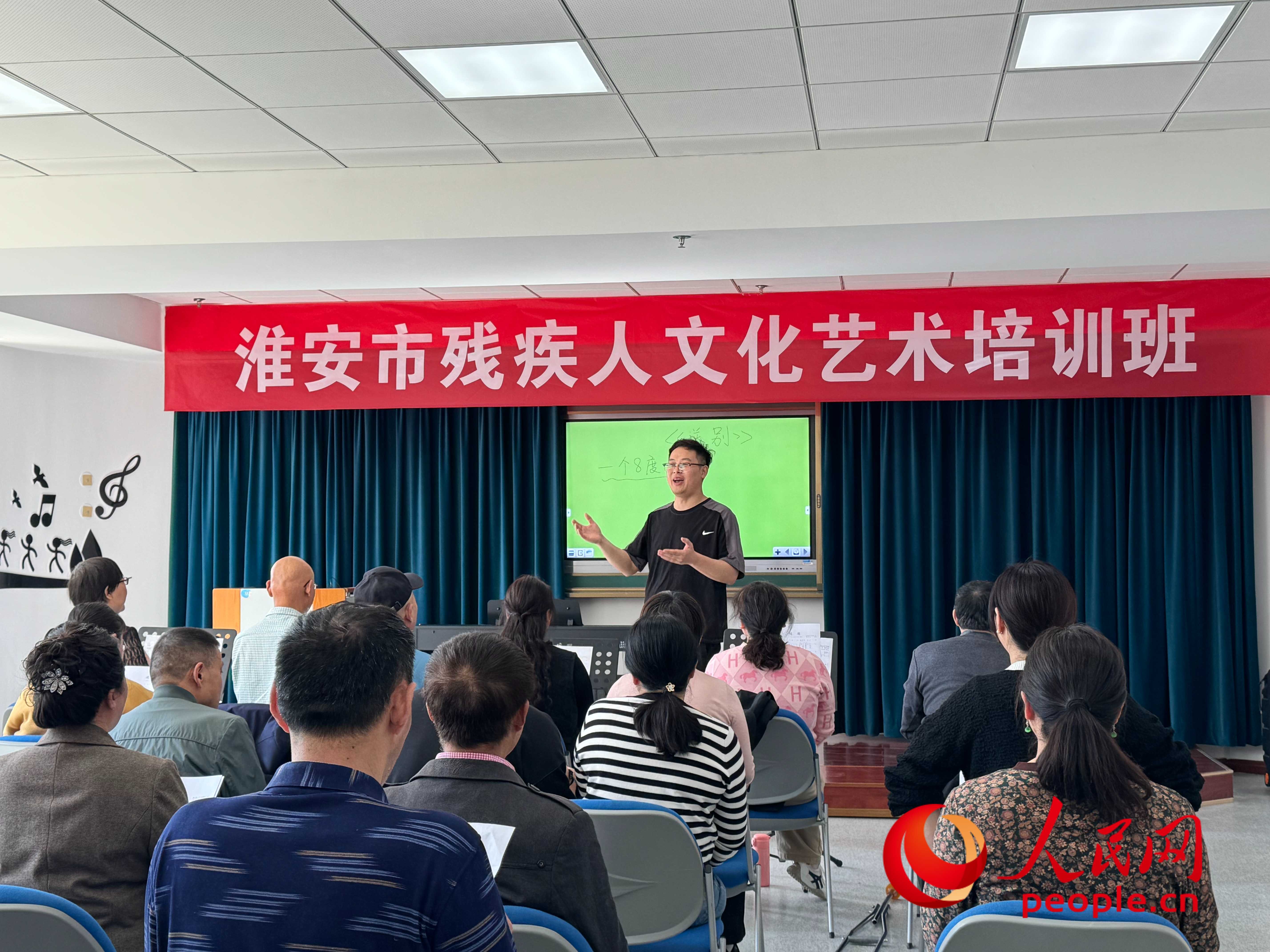 在淮安市殘疾人文化藝術(shù)培訓(xùn)班上，聲樂老師在教殘疾人唱《送別》這首歌曲。人民網(wǎng) 周靜圓攝