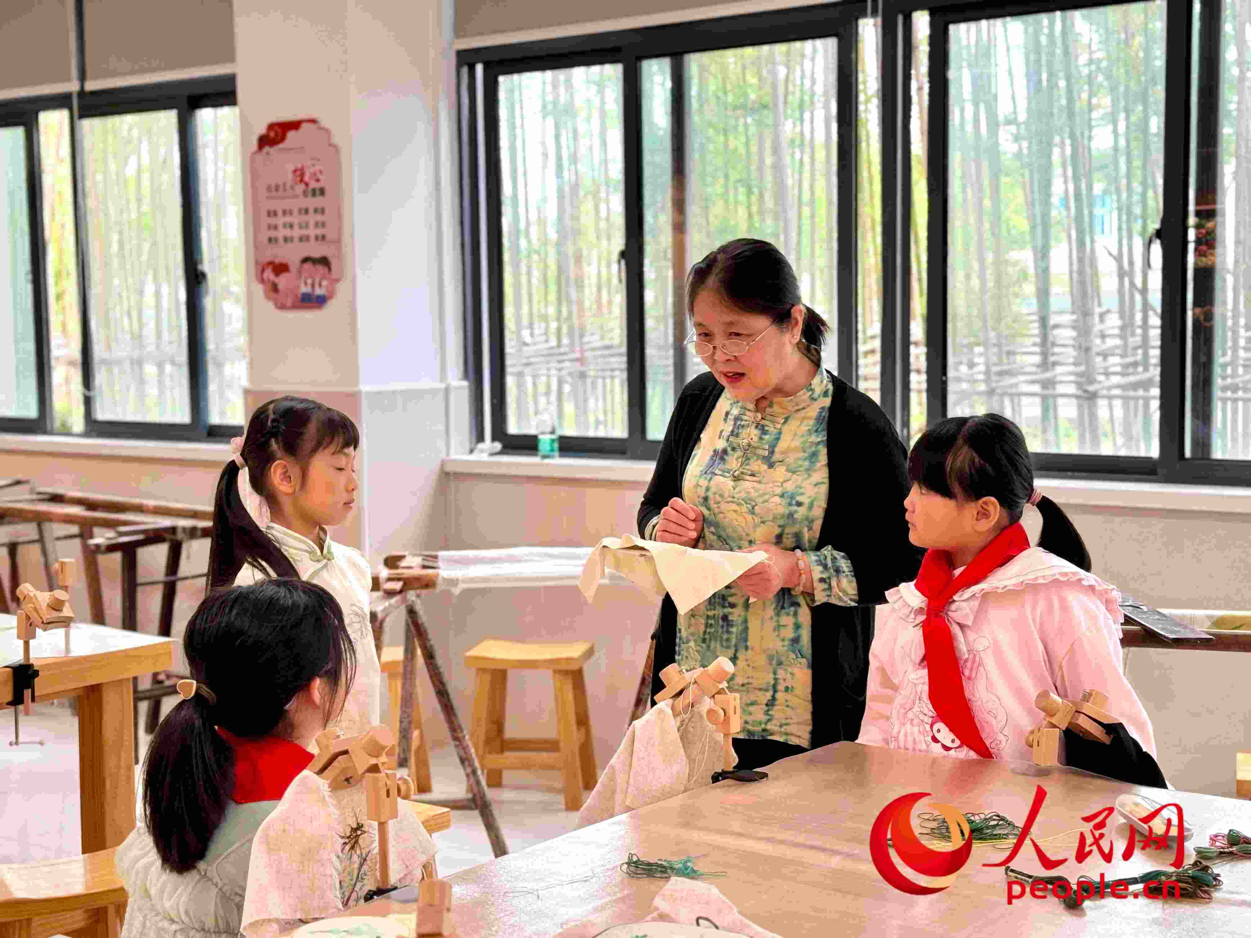 顧建珍（左三）在教孩子們刺繡知識。人民網(wǎng) 周靜圓攝