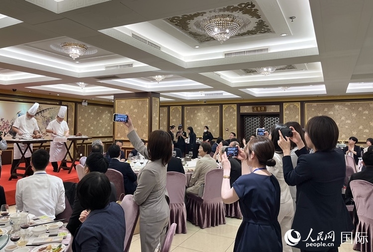 國家級非物質文化遺產(chǎn)、全聚德片鴨工藝吸引代表團成員拍照留念。