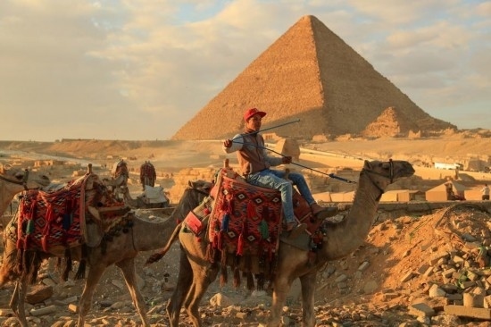 1月24日，商販騎駱駝離開埃及吉薩金字塔景區(qū)。新華社記者 隋先凱 攝