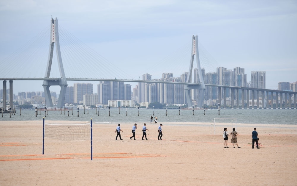 2023年7月17日，廣東湛江五環(huán)廣場的沙灘上，公安民警在執(zhí)勤巡邏。新華社記者 鄧華 攝