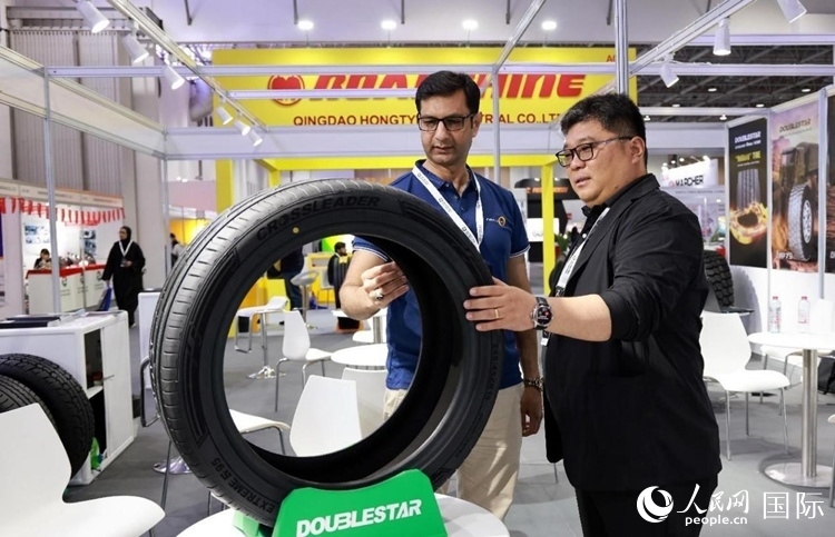 工作人員向客戶展示雙星電動汽車輪胎。和傳統(tǒng)汽車輪胎相比，電動汽車輪胎具有更高承載能力、更加靜音舒適、更好極速抓地、更低滾動阻力等特點(diǎn)。人民網(wǎng)記者 管克江攝