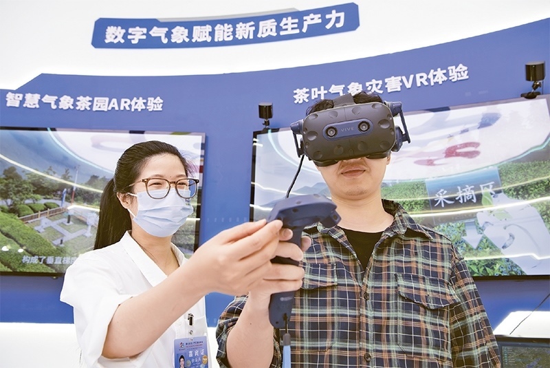 2024年5月23日，第七屆數(shù)字中國(guó)建設(shè)峰會(huì)現(xiàn)場(chǎng)體驗(yàn)區(qū)在福州海峽國(guó)際會(huì)展中心向?qū)I(yè)觀眾開(kāi)放。本次現(xiàn)場(chǎng)體驗(yàn)區(qū)圍繞本屆峰會(huì)主題“釋放數(shù)據(jù)要素價(jià)值，發(fā)展新質(zhì)生產(chǎn)力”，設(shè)置“數(shù)字惠民”、“數(shù)字能力”、“數(shù)字基礎(chǔ)”、“數(shù)字生態(tài)”、“數(shù)字賦能”五大板塊。圖為一名觀眾（右）在數(shù)字氣象賦能新質(zhì)生產(chǎn)力展臺(tái)上進(jìn)行體驗(yàn)。 新華社記者 魏培全/攝