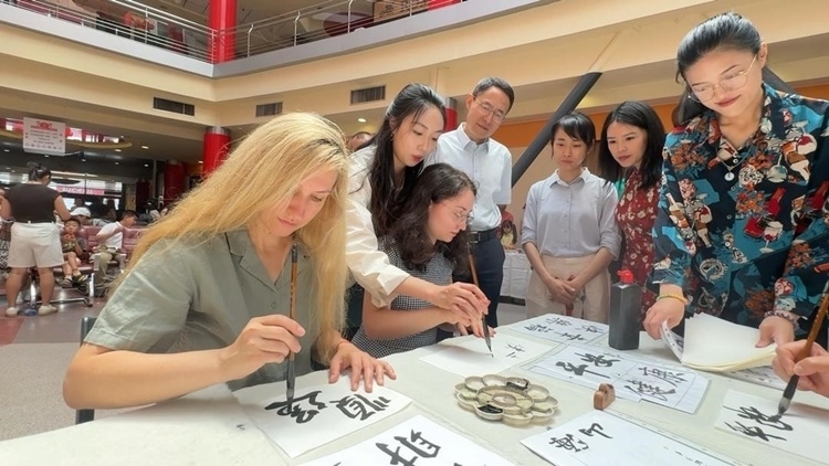 羅馬尼亞友人在活動(dòng)現(xiàn)場(chǎng)學(xué)寫漢字。中國(guó)駐羅馬尼亞大使館領(lǐng)僑處供圖