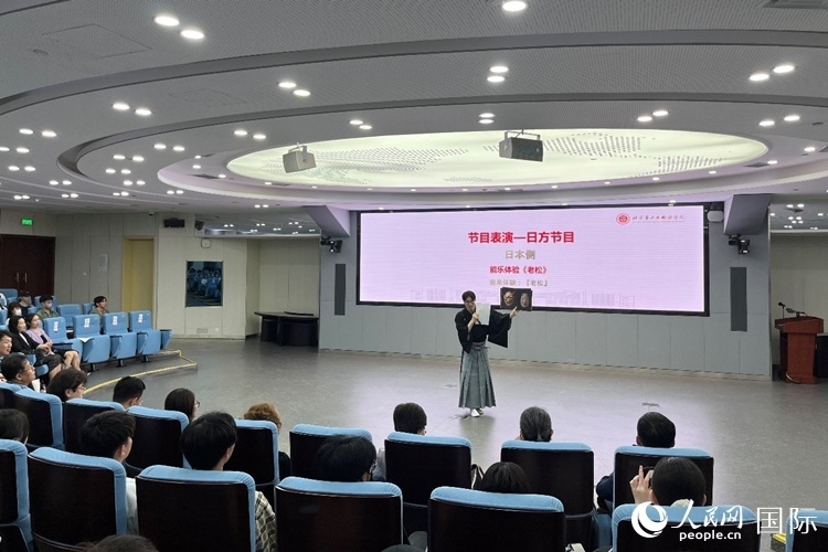 日本大學(xué)生介紹能樂知識。人民網(wǎng)記者 陳思攝