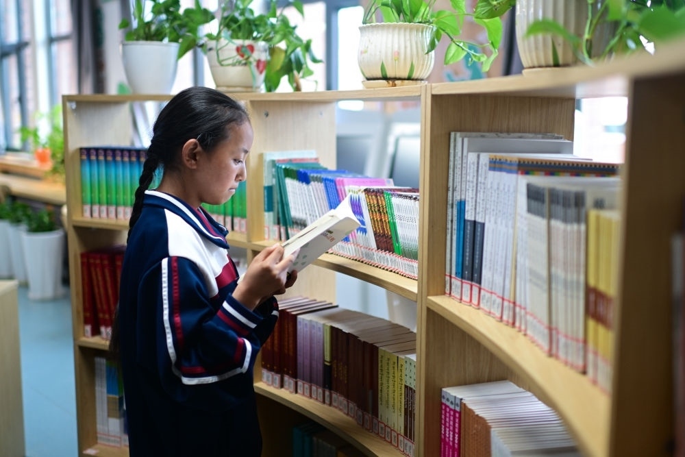 6月18日，果洛西寧民族中學(xué)學(xué)生尼東拉毛在圖書室看書。