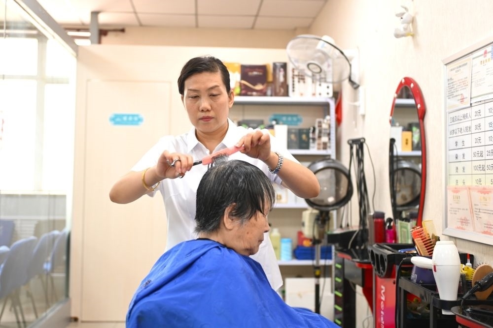 6月20日，長(zhǎng)城花園社區(qū)的志愿者為居民理發(fā)。