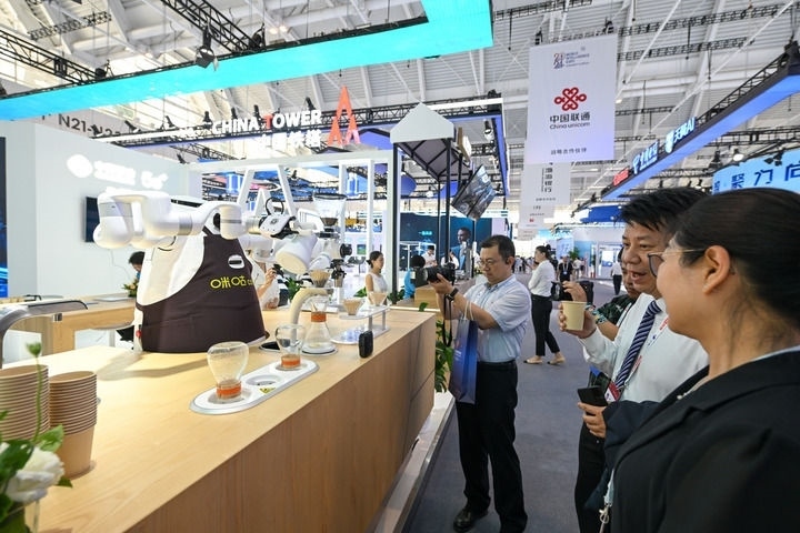 6月20日，與會(huì)者品嘗機(jī)器人沖調(diào)出的咖啡。新華社記者 孫凡越 攝