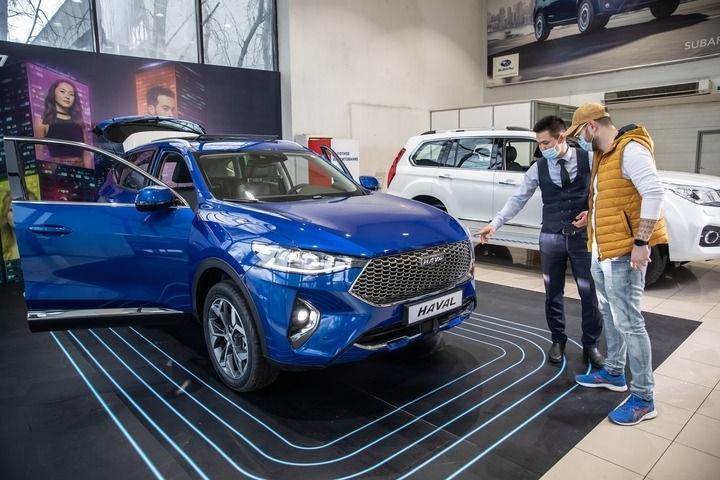 2021年4月1日，銷(xiāo)售人員在哈薩克斯坦阿拉木圖市經(jīng)銷(xiāo)商店向消費(fèi)者介紹哈弗汽車(chē)。新華社發(fā)（阿斯塔納汽車(chē)公司供圖）