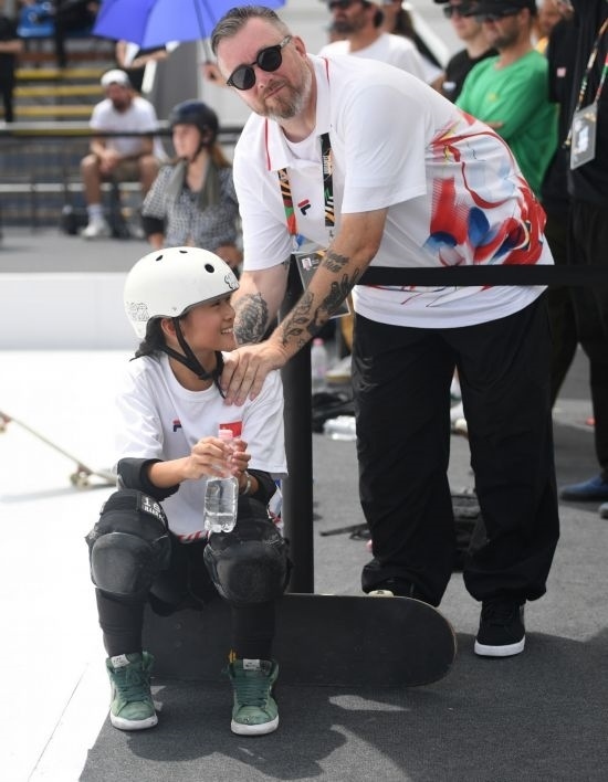 6月20日，鄭好好（左）在比賽間隙與教練互動(dòng)，她在預(yù)賽中最佳成績?yōu)?2.60分。當(dāng)日，巴黎奧運(yùn)會資格系列賽布達(dá)佩斯站滑板女子碗池預(yù)賽在布達(dá)佩斯舉行。新華社記者 賀燦鈴 攝