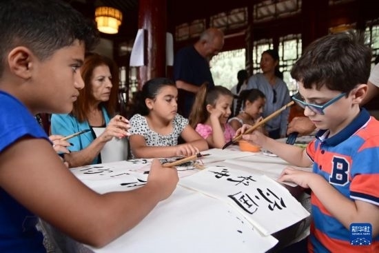 7月4日，在馬耳他桑塔露琪亞市的中國古典園林“靜園”，人們體驗中國書法。新華社發(fā)（喬納森·博格 攝）