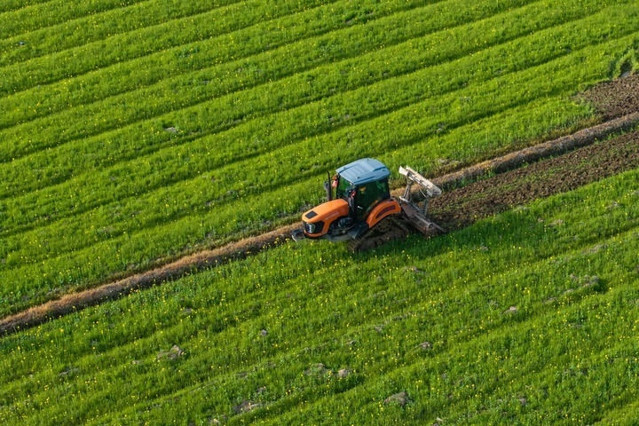 2024年3月19日，在湖南省常德市鼎城區(qū)謝家鋪鎮(zhèn)港中坪村，村民駕駛農(nóng)機翻耕田地（無人機照片）。新華社記者 陳思汗 攝
