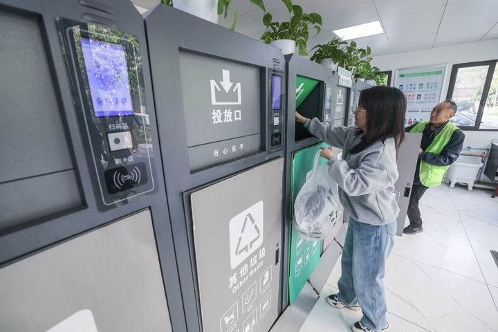 2024年4月10日，在浙江省湖州市吳興區(qū)飛英街道新華府小區(qū)內(nèi)，居民在垃圾分類智能系統(tǒng)的指導下進行垃圾分類投放，居民的投放情況將實時匯總到智慧服務平臺，會有相應的積分獎勵。新華社記者 徐昱 攝