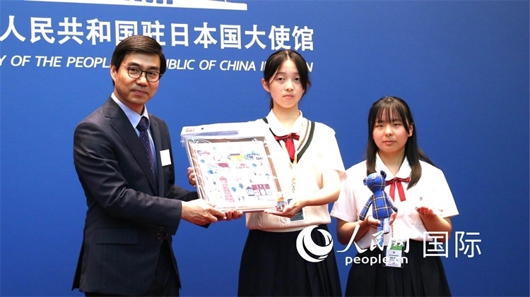 日本小大使向中國駐日本大使館臨時(shí)代辦施泳贈(zèng)送當(dāng)?shù)靥厣Y品。人民網(wǎng) 許可攝