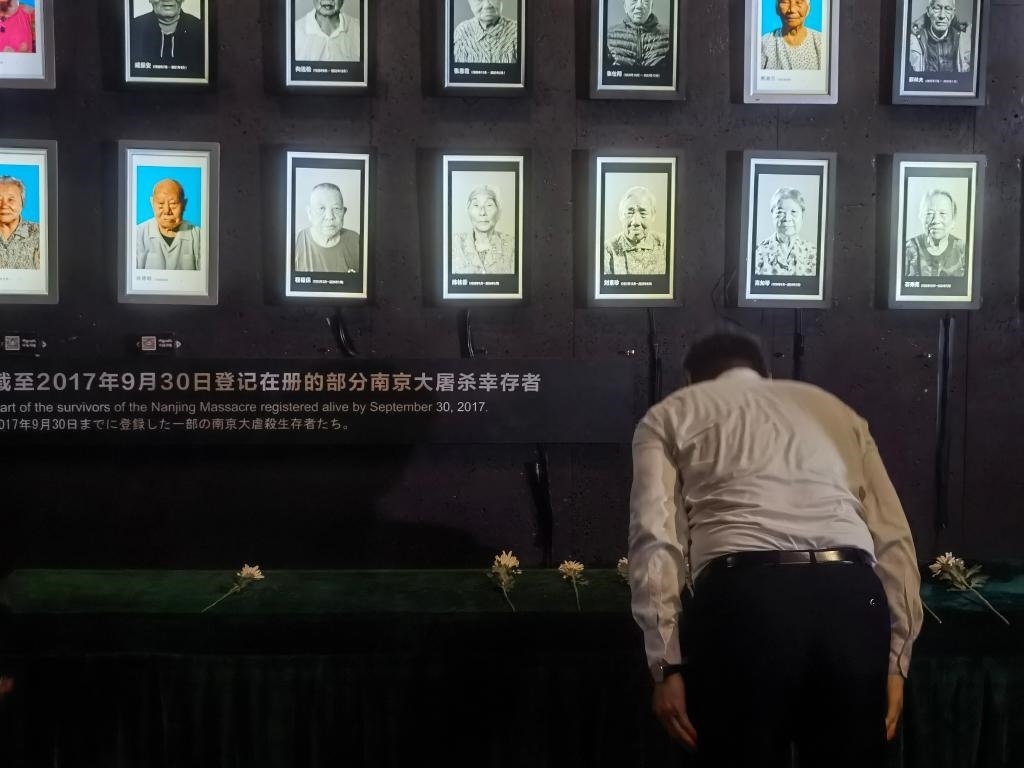 7月18日，人們向離世的南京大屠殺幸存者獻(xiàn)花、鞠躬。新華社記者邱冰清 攝