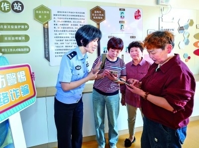浙江湖州民警指導(dǎo)居民加入湖州“e企安”微信群，實(shí)時(shí)接收反詐信息。新華社發(fā)