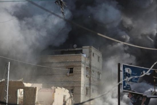 7月21日，在加沙地帶中部的努賽賴特難民營，遭以軍空襲的建筑冒出滾滾濃煙。新華社發(fā)（馬爾萬·達烏德攝）