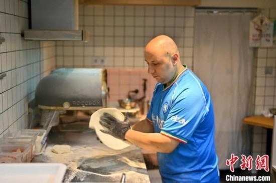 近日，韋榮耀在自家披薩小店內(nèi)忙活。俞靖 攝