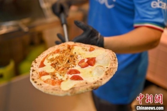 近日，韋榮耀展示他制作的“老友味”披薩。 俞靖 攝