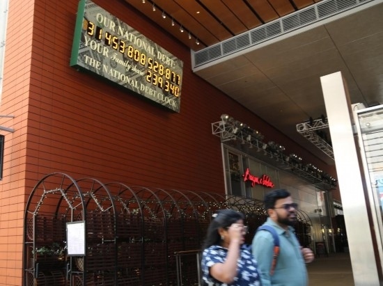 2023年5月29日，人們經(jīng)過美國紐約曼哈頓的“國債鐘”?！皣鴤姟笔且粋€大型計數(shù)器，它實時更新美國的公共債務(wù)總額，并顯示出每個美國家庭所要負(fù)擔(dān)的數(shù)額。 新華社記者劉亞南攝