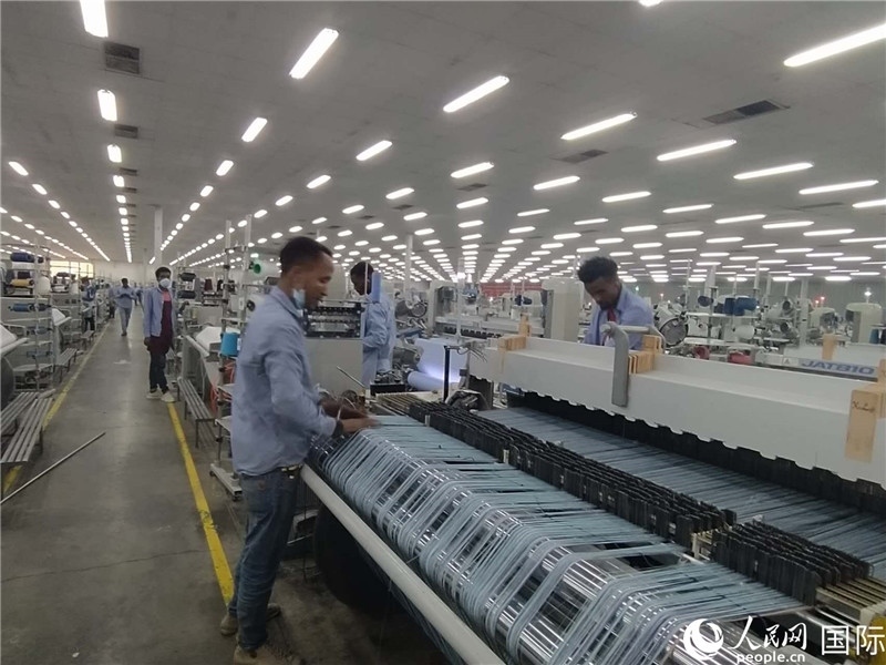 無錫金茂埃塞面料廠車間內(nèi)，當(dāng)?shù)毓と苏谝唤z不茍地作業(yè)。人民網(wǎng)記者 黃培昭攝