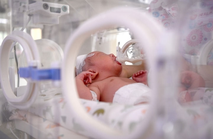 2024年6月1日，在西安國際醫(yī)學中心醫(yī)院新生兒科病房，護士為新生兒喂奶。 新華社記者 劉瀟 攝