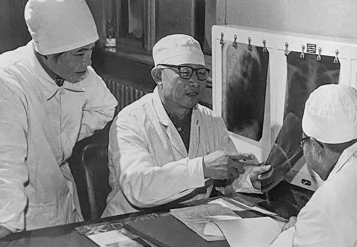 1980年1月16日，中日友好醫(yī)院首任院長辛育齡（中）在內(nèi)蒙古結(jié)核病院與胸外科醫(yī)師討論病例（翻拍照片）。 新華社發(fā)