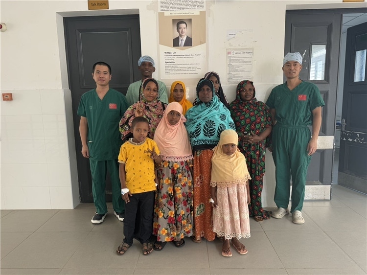 李廣（右一）和王林醫(yī)生與部分患者合影。中國援桑醫(yī)療隊供圖