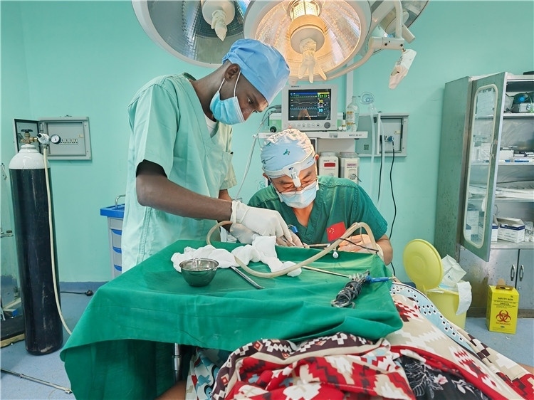 李廣醫(yī)生與當?shù)蒯t(yī)生在做手術(shù)中。中國援桑醫(yī)療隊供圖
