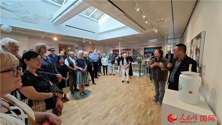 參展人、景德鎮(zhèn)陶瓷大學(xué)美術(shù)學(xué)院副院長邵長宗（右一）向來賓介紹參展作品。人民網(wǎng)記者 殷淼攝