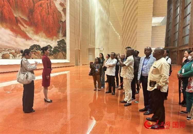 代表團(tuán)在入口處聽取講解。人民網(wǎng) 曹欣悅攝