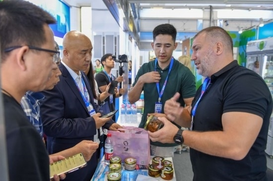 2023年8月23日，在第十四屆中國—東北亞博覽會東北亞商品館，俄羅斯參展商向參觀者介紹商品。