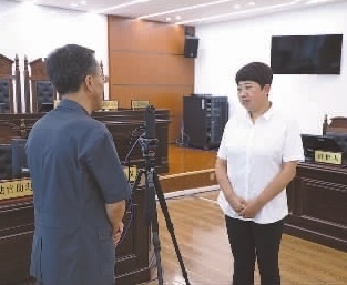 圖為全國(guó)人大代表玉明姬（右）詳細(xì)了解環(huán)境資源審判工作情況。劉思妤 攝