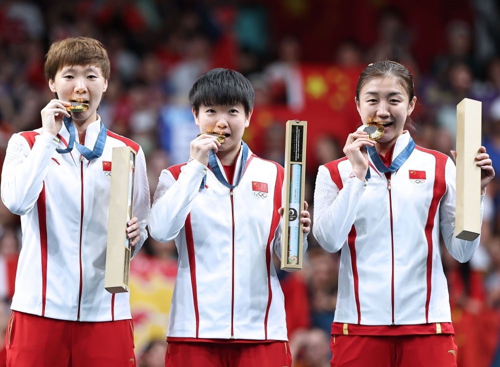 冠軍中國隊選手王曼昱、孫穎莎、陳夢（從左至右）在巴黎奧運會乒乓球女子團體頒獎儀式上（2024年8月10日攝）。新華社記者 王東震 攝