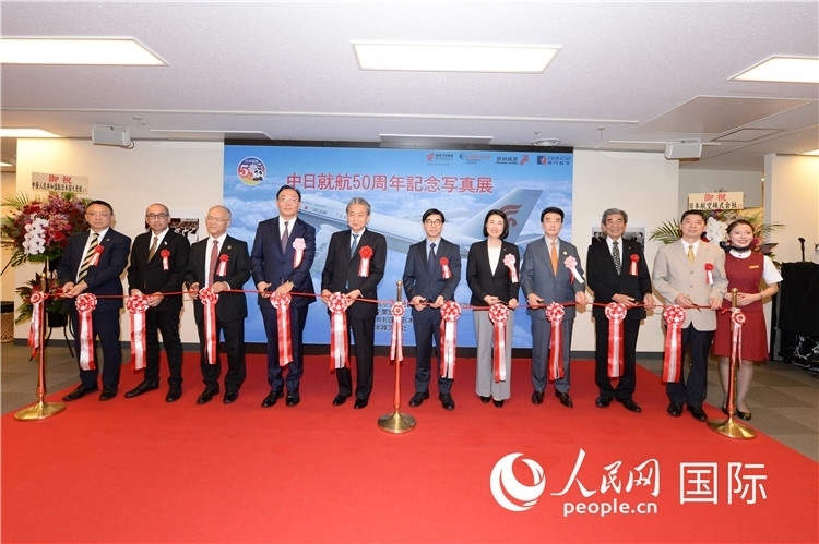 與會(huì)嘉賓共同為中日通航50周年紀(jì)念圖片展開(kāi)幕剪彩。馮學(xué)敏攝
