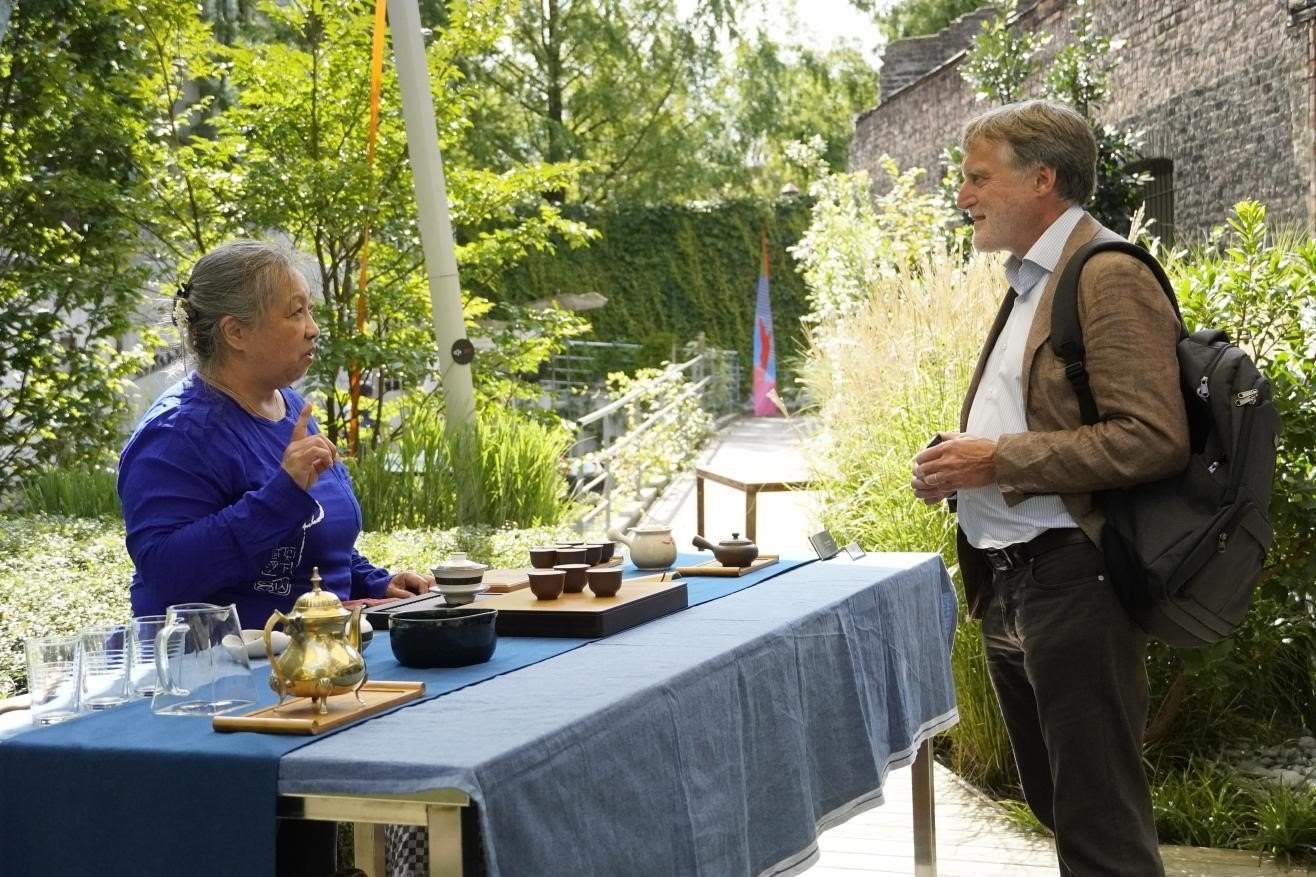 在博物館的戶外花園來賓品味中國茶藝。比利時維他命文化傳媒供圖
