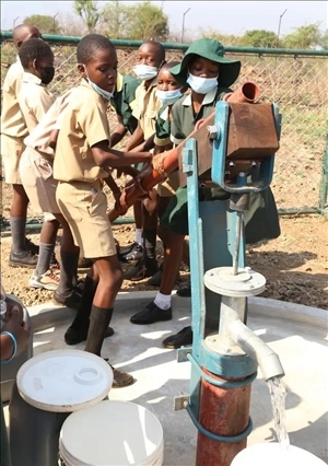 △2021年11月，在津巴布韋南馬塔貝萊蘭省省會關達的塞農(nóng)多小學，學生從中國援建水井里打水。