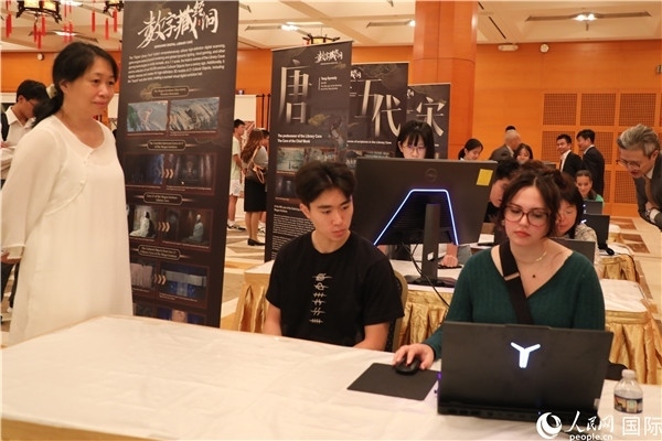 在活動(dòng)現(xiàn)場(chǎng)，當(dāng)?shù)孛癖婓w驗(yàn)“數(shù)字藏經(jīng)洞”云游戲，沉浸式體驗(yàn)敦煌文化。 人民網(wǎng)記者 李志偉攝