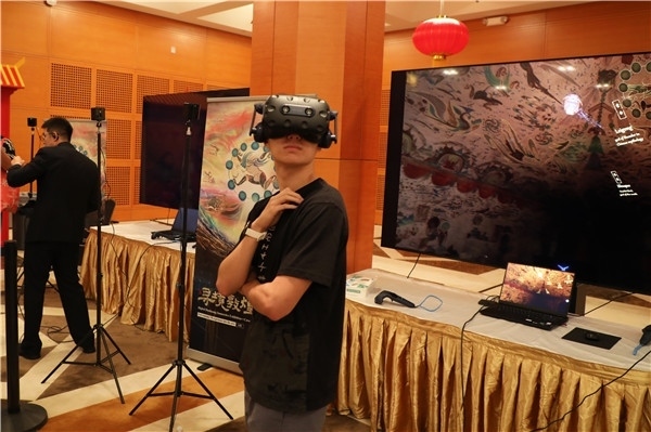 1、在本次活動(dòng)的展覽現(xiàn)場(chǎng)，敦煌研究院與騰訊展示了“數(shù)字藏經(jīng)洞”和“尋境敦煌”等創(chuàng)新互動(dòng)產(chǎn)品。圖為當(dāng)?shù)孛癖娡ㄟ^(guò)VR虛擬游覽洞窟。 人民網(wǎng)記者 李志偉攝
