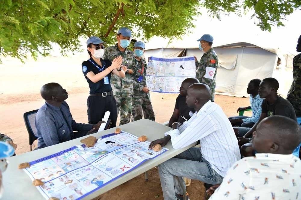 2020年3月，在南蘇丹首都朱巴，執(zhí)行聯(lián)合國維和任務(wù)的中國維和警察廖潔給當(dāng)?shù)鼐熘v解防疫知識(shí)。