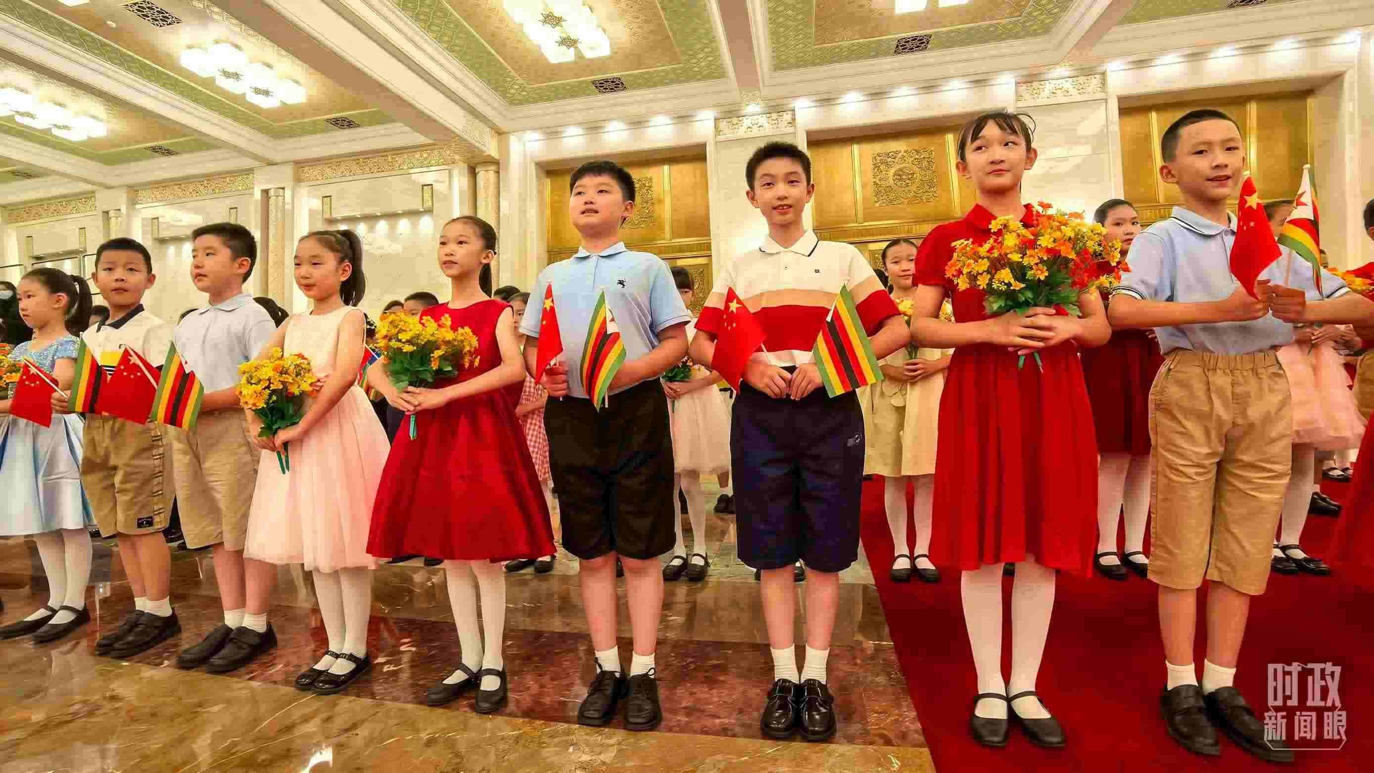 △現(xiàn)場歡迎津巴布韋總統(tǒng)訪華的青少年。（總臺(tái)央視記者鐘銳拍攝）