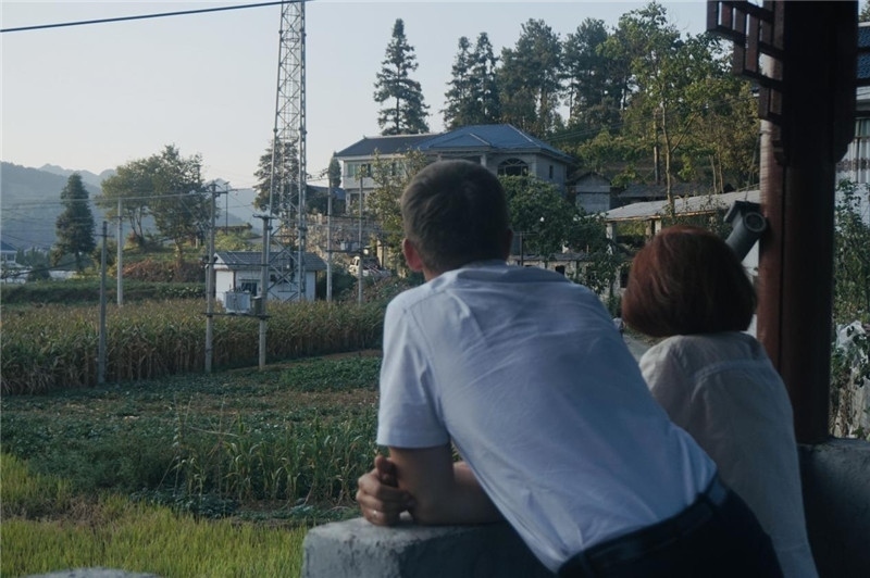 望得見山，看得見水，記得住鄉(xiāng)愁。每個人心中都有一個屬于自己的“花茂村”，在這方心田，走遍千山萬水，鄉(xiāng)音未改鬢毛衰。吉爾吉斯斯坦《比什凱克晚報(bào)》第一副總編輯妮娜·尼奇博洛娃與《中國與俄羅斯》雜志社社長奧列格·別列日內(nèi)赫攝在花茂村民居屋檐下并肩佇立，眺望山水，尋覓鄉(xiāng)愁。（李光裕攝）