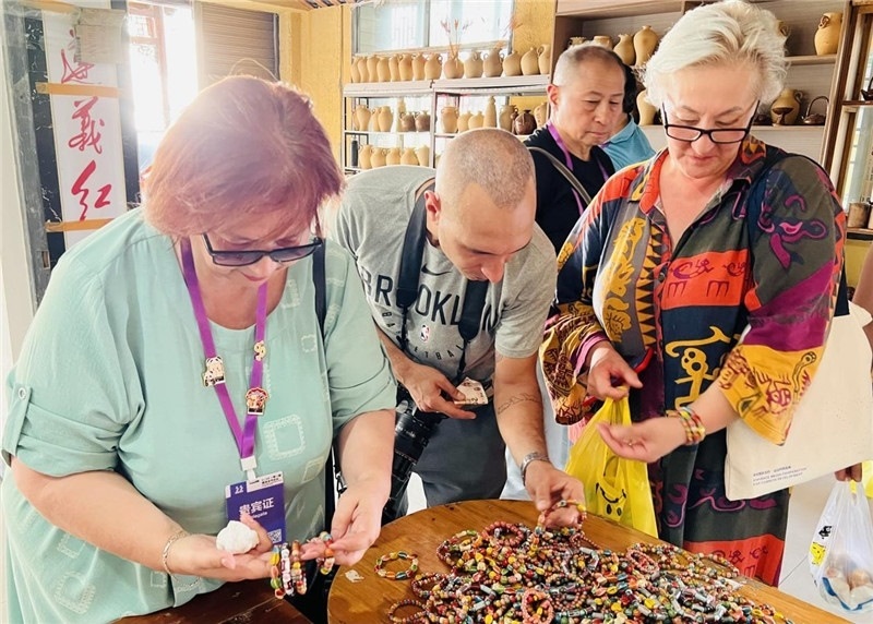 歐亞媒體考察團(tuán)成員在母氏陶藝館內(nèi)挑花了眼，色彩絢麗、質(zhì)地均勻的陶藝手串讓他們愛不釋手?！斑@里的東西都太實(shí)惠了！”塔吉克斯坦《索格特真理報(bào)》政論部主任娜塔利婭·多羅費(fèi)耶娃說?；宓奶厣a(chǎn)品物美價(jià)廉，讓考察團(tuán)成員為家人好友買到了心儀的禮物，也為此次以四川成都為起點(diǎn)，路經(jīng)南充、廣安至貴州遵義的考察行程畫上了圓滿句號。（張亞欣攝）